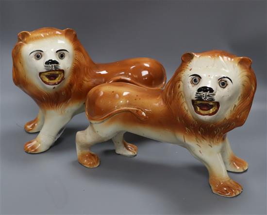 A pair of Staffordshire pottery figures of lions, 1910 width 32cm